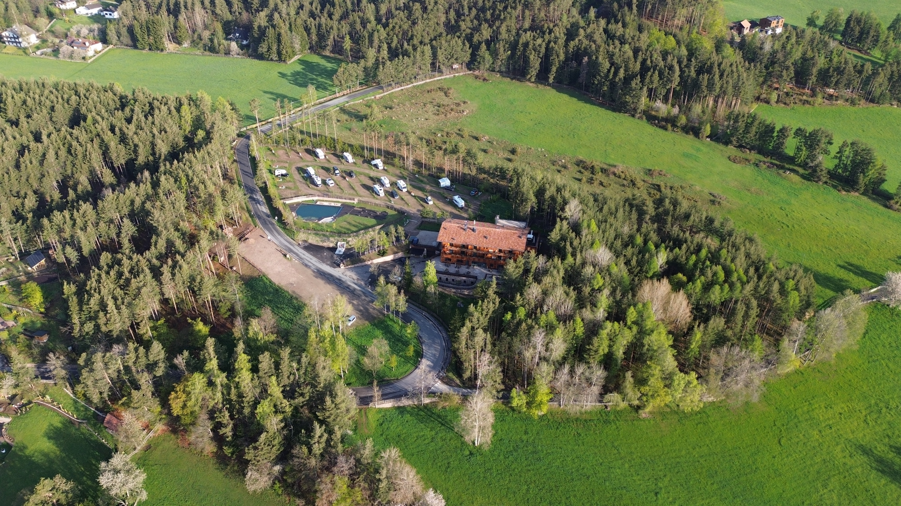 Blick auf das Bergdorf Schartneralm mit einem einladenden Schwimmbad inmitten der malerischen Landschaft