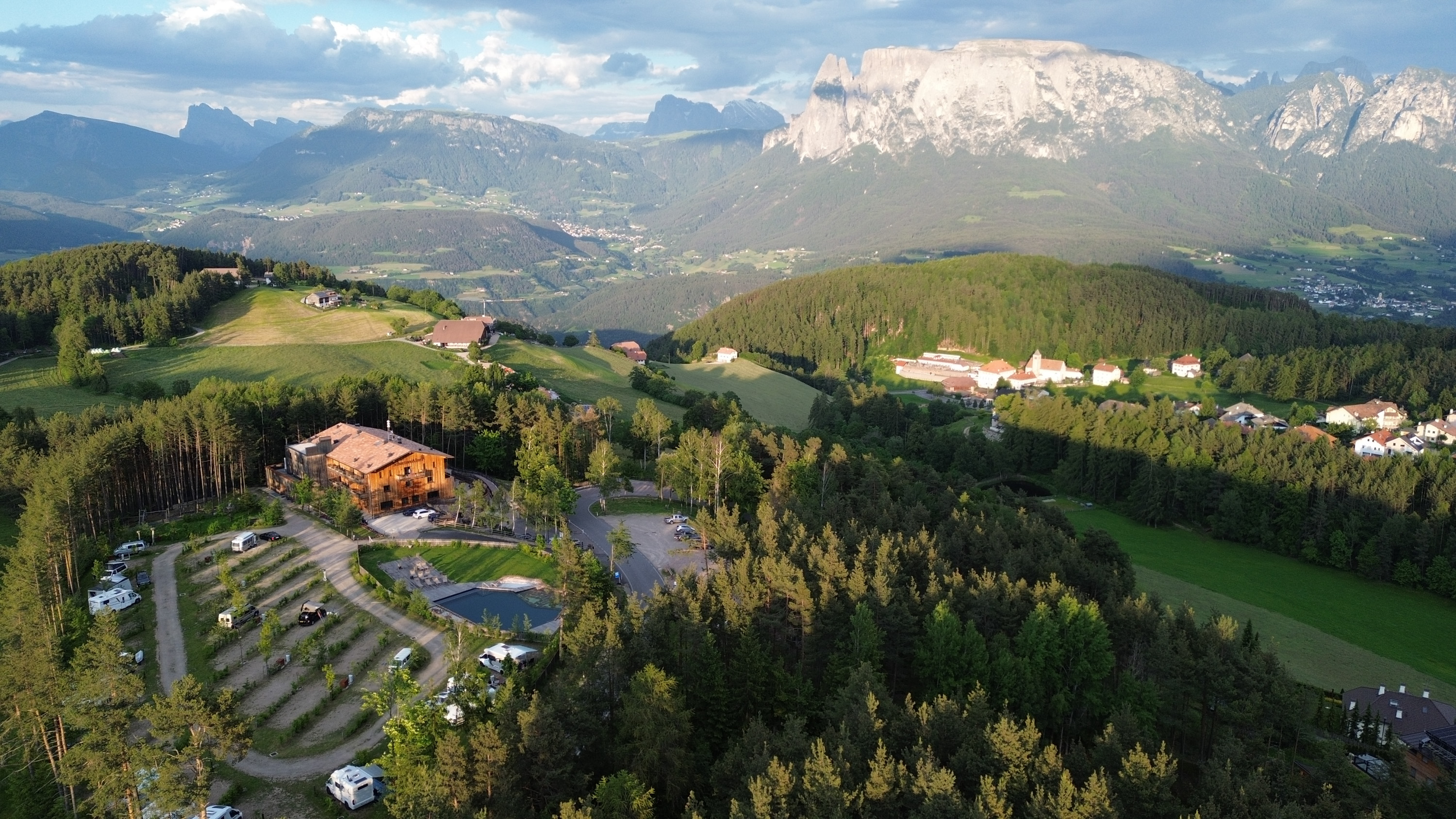 Blick auf das Bergdorf Schartneralm mit einem einladenden Schwimmbad inmitten der malerischen Landschaft